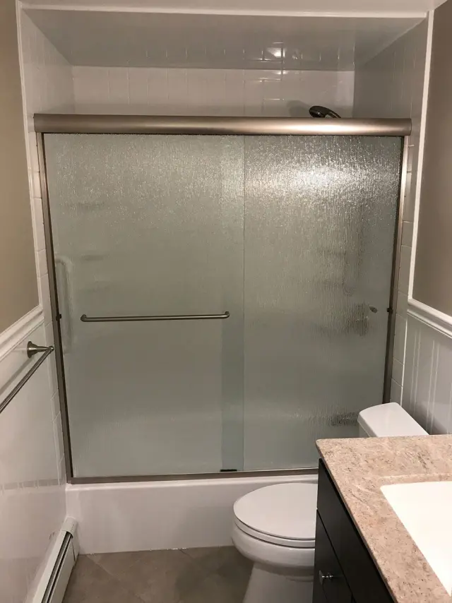 Sliding semi-frameless shower door installed in Hingham