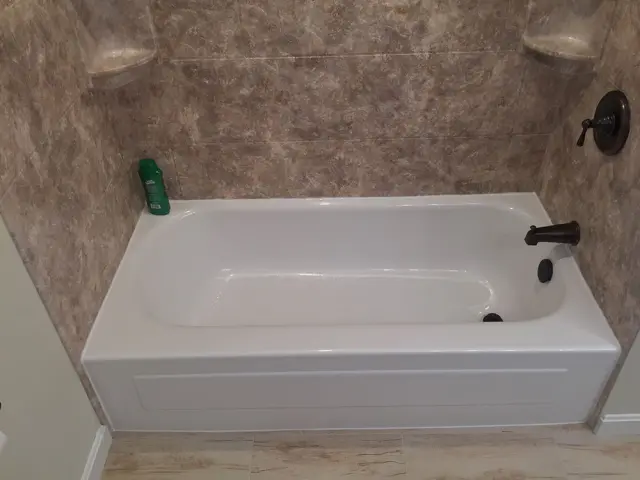 White acrylic soaking tub with river rock walls in Marshfield